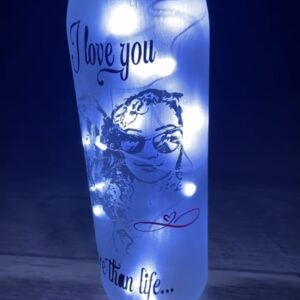 Decorative bottle with a glowing interior, featuring a design that reads "I love you more than life," alongside a playful illustration.
