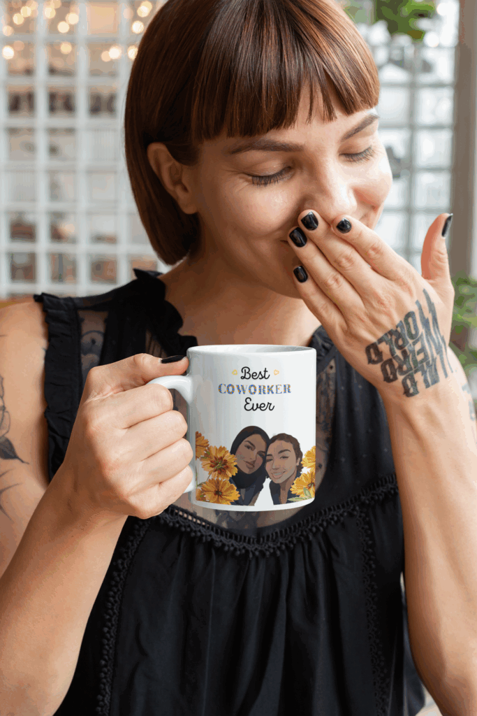 Woman in a black blouse smiles while holding a mug that reads "Best Coworker Ever," featuring illustrated faces and flowers.